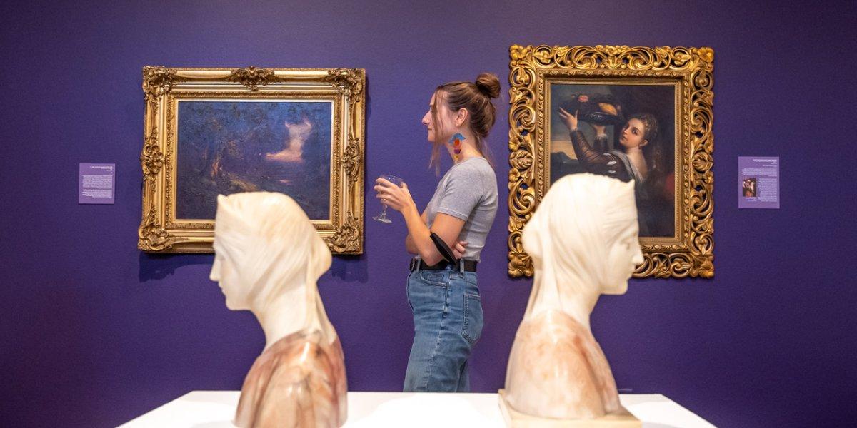 一个学生站在艺术博物馆的两个半身像之间